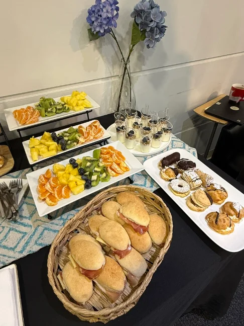 Estación de brunch con fruta fresca, sándwiches y repostería
